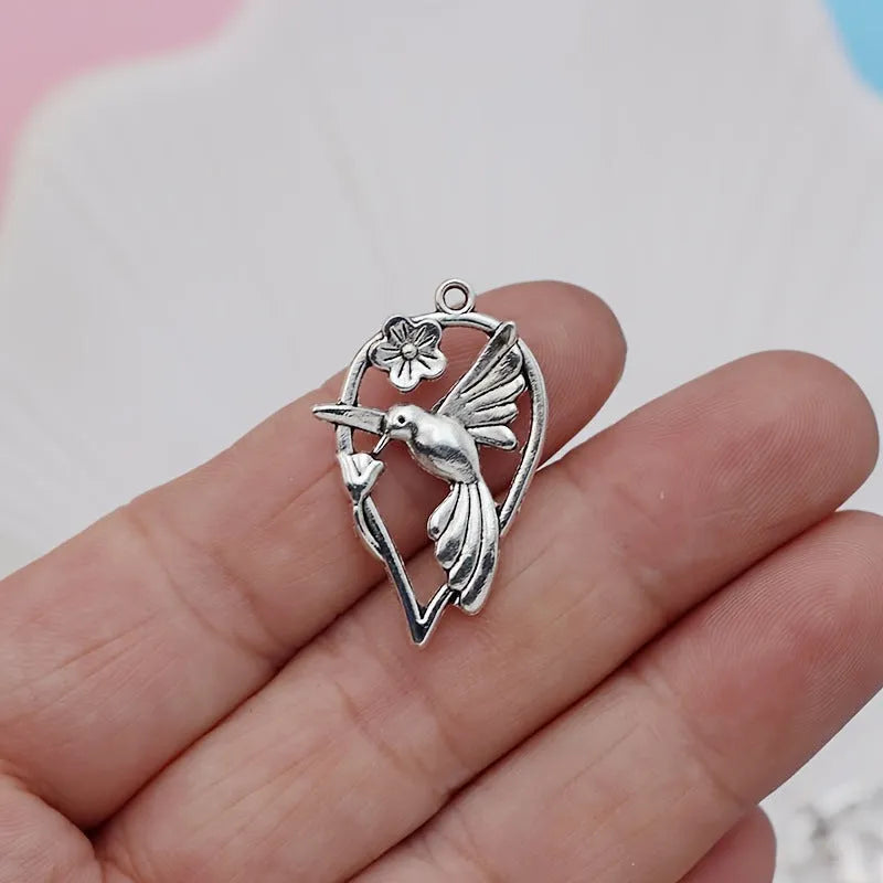 Close-up of a silver-toned alloy cuckoo bird pendant with a magpie pattern, for DIY jewellery making.