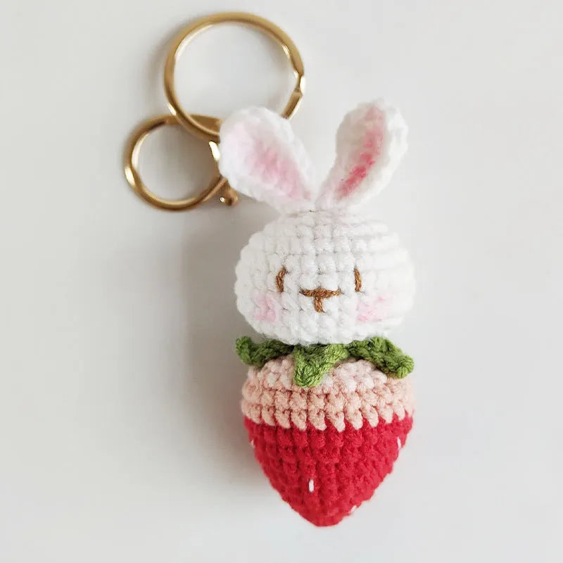 Hand-woven white doll wire rabbit strawberry pendant on a key chain.