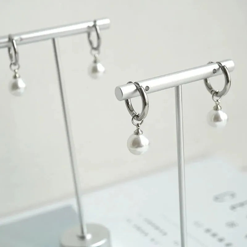 Geometric pearl drop earrings with titanium steel alloy construction and round element accents