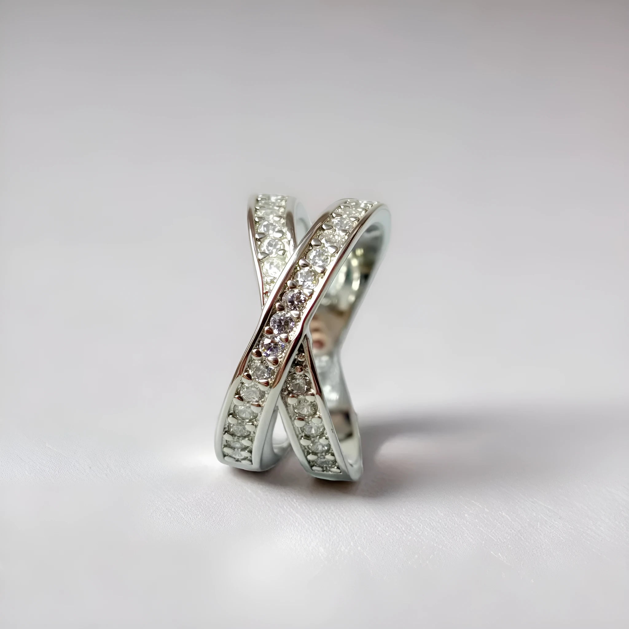 A silver or rose gold metal ring featuring a cross design with micro-inlaid zircon stones, shown in sizes 6 to 9.