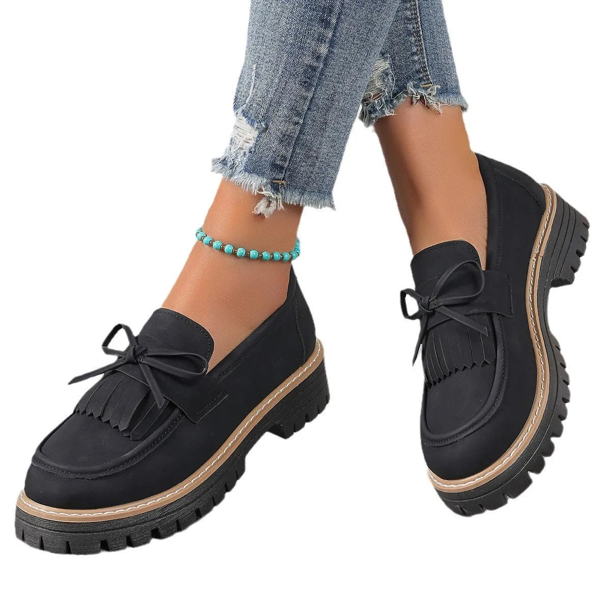 Black faux leather women's loafers with a tassel decoration and a thick chunky heel