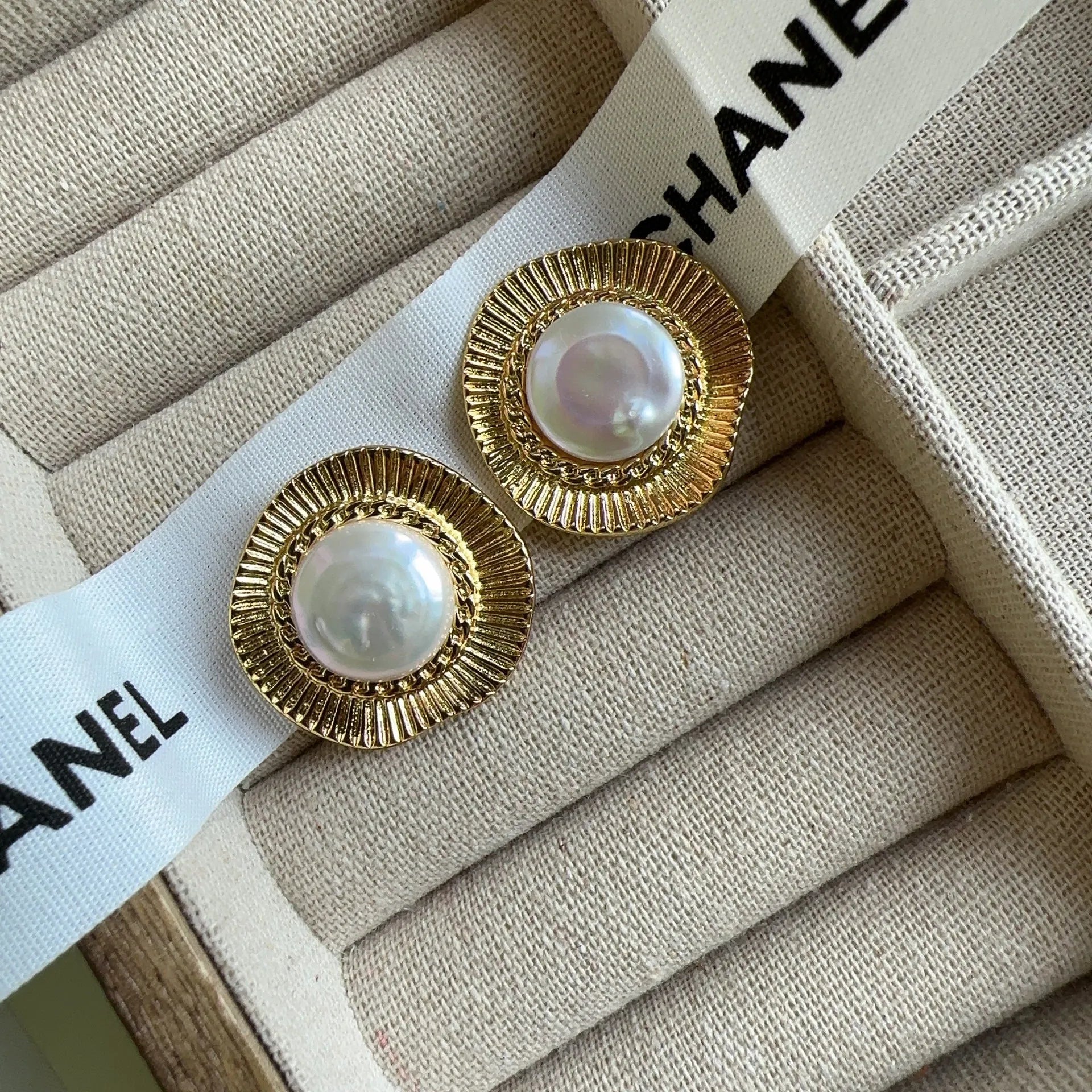 A pair of round, gold-tone retro style metal earrings for women