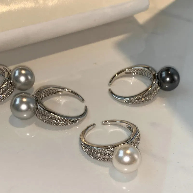 Adjustable geometric copper ring for women with a black pearl on an open band.