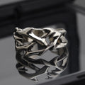 Copper men's ring with geometric thorn and flower design on an adjustable band.