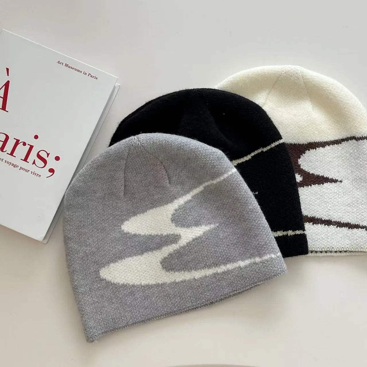 Acrylic thermal knit beanie hat in black on a white background, showing ribbed texture.