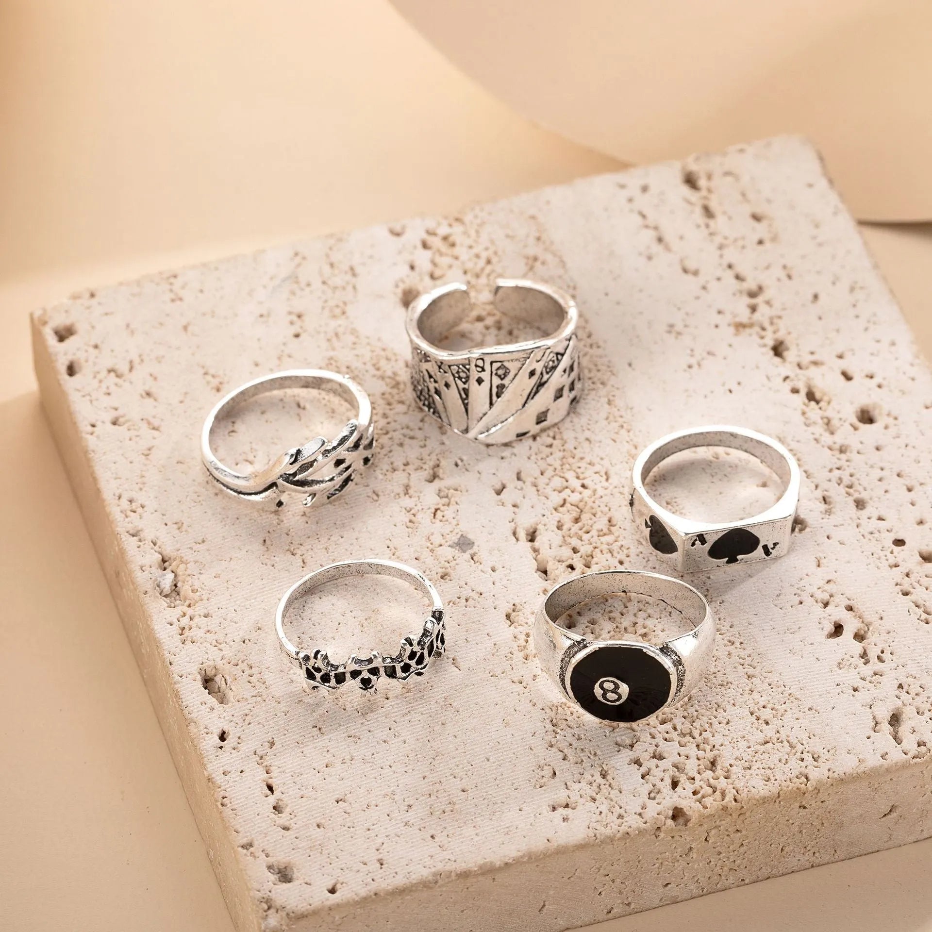 Black alloy ring with a detailed retro spade card poker design on a finger.