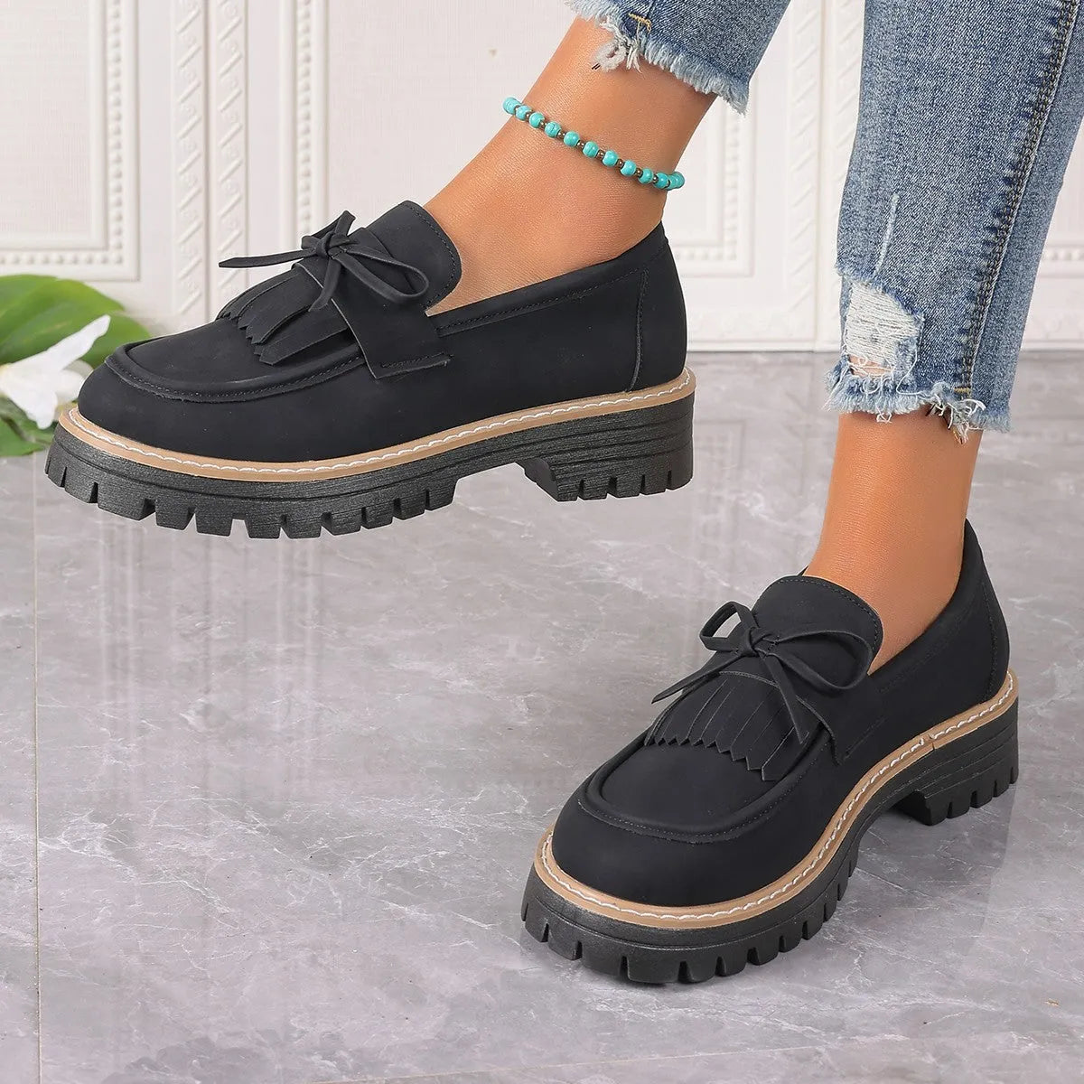 Black faux leather women's loafers with a tassel decoration and a thick chunky heel
