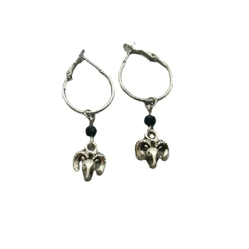 A pair of silver-coloured alloy round ring hoop earrings on a plain background.