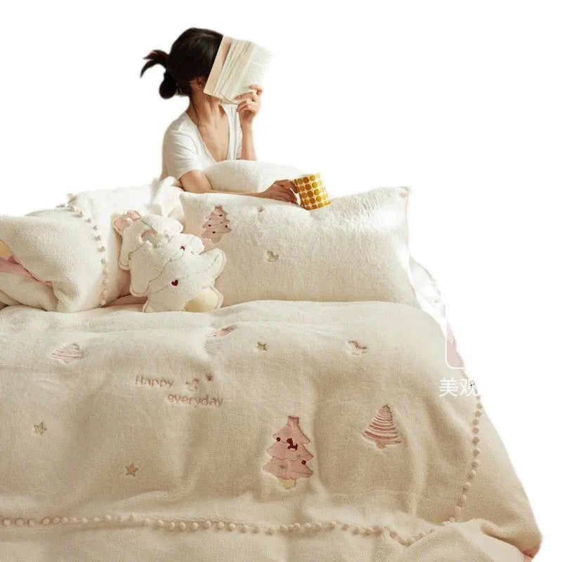 Winter milk fibre four-piece bedding set with printed green Christmas tree pattern on a bed.