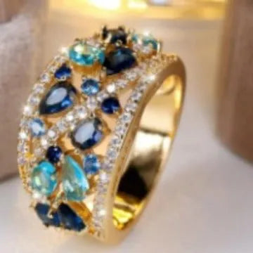 Women's round copper ring with hollow openwork centre in gold sapphire blue colour.