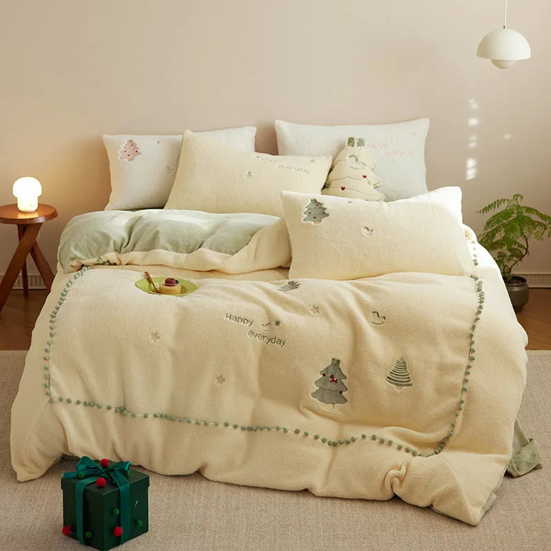 Winter milk fibre four-piece bedding set with printed green Christmas tree pattern on a bed.
