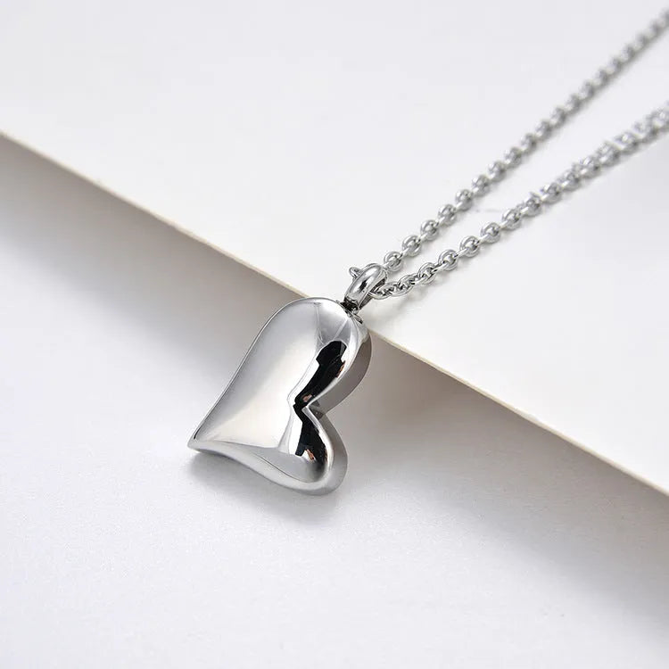 Silver curved peach heart pendant necklace on a chain with extension