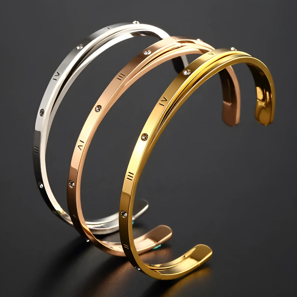 Open-ended stainless steel bracelet with zircon inlays in a love theme, shown in gold colour.