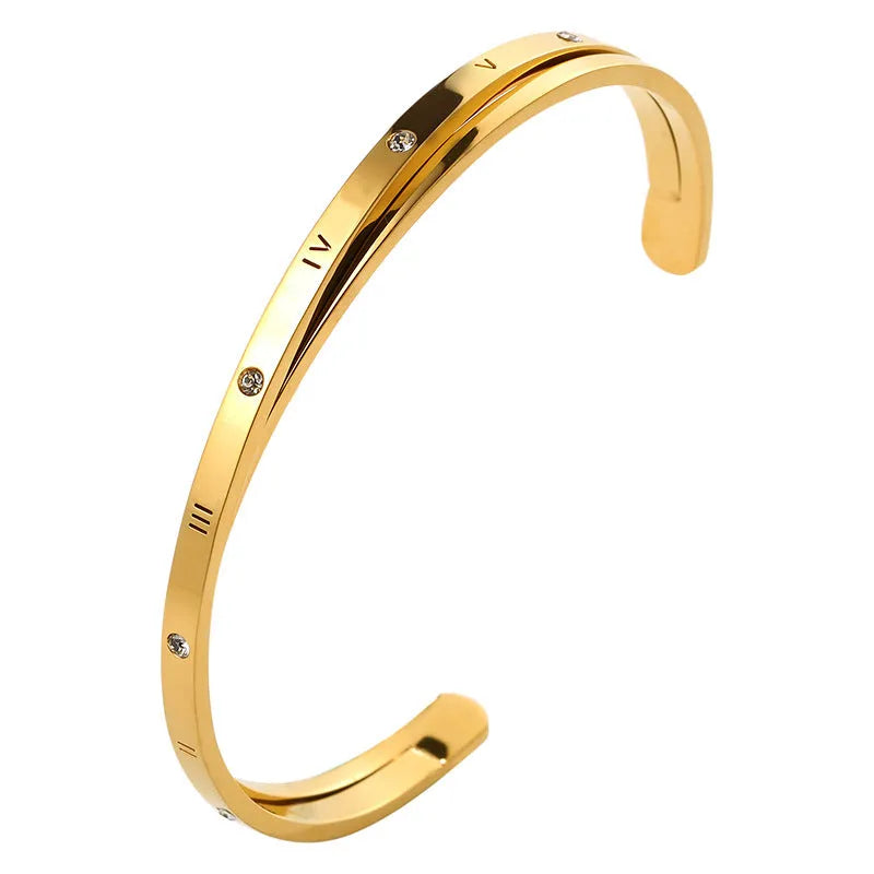 Open-ended stainless steel bracelet with zircon inlays in a love theme, shown in gold colour.