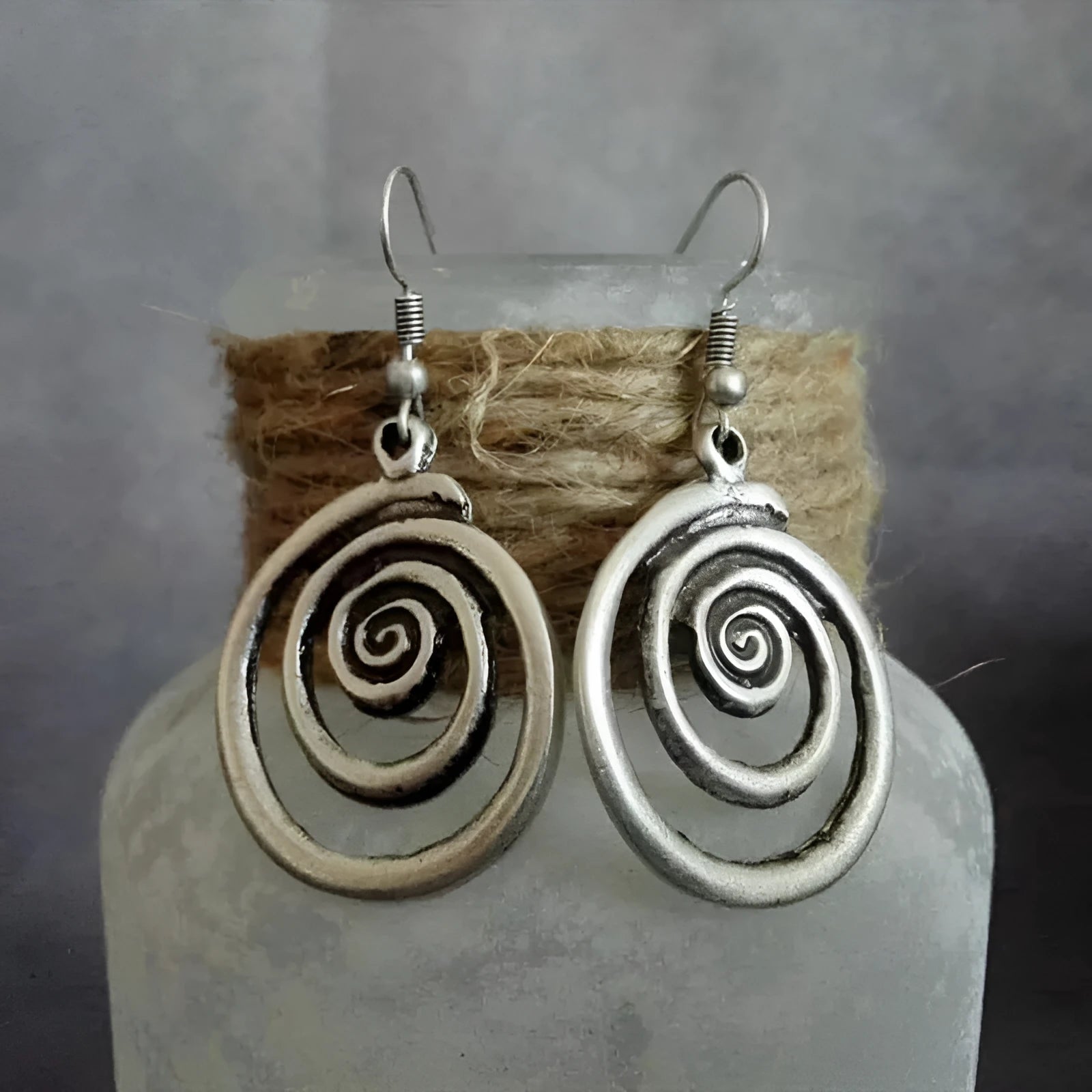 Silver geometric spiral distressed retro style earrings with a folk art design