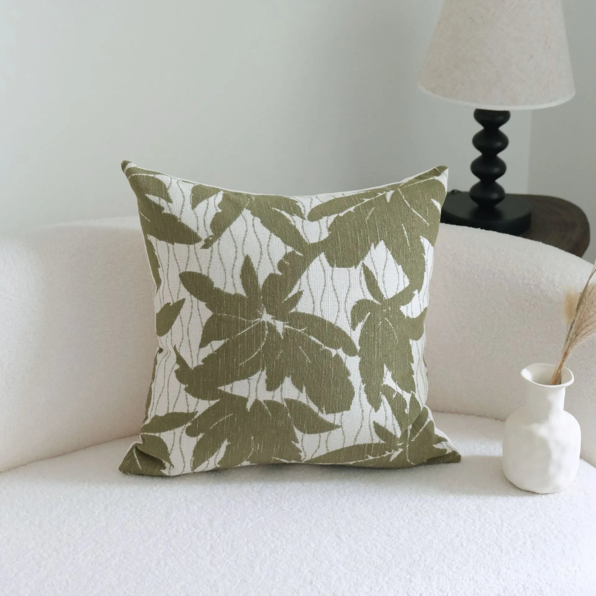Green decorative pillow with tassel or beaded design on a cotton linen blend cover.