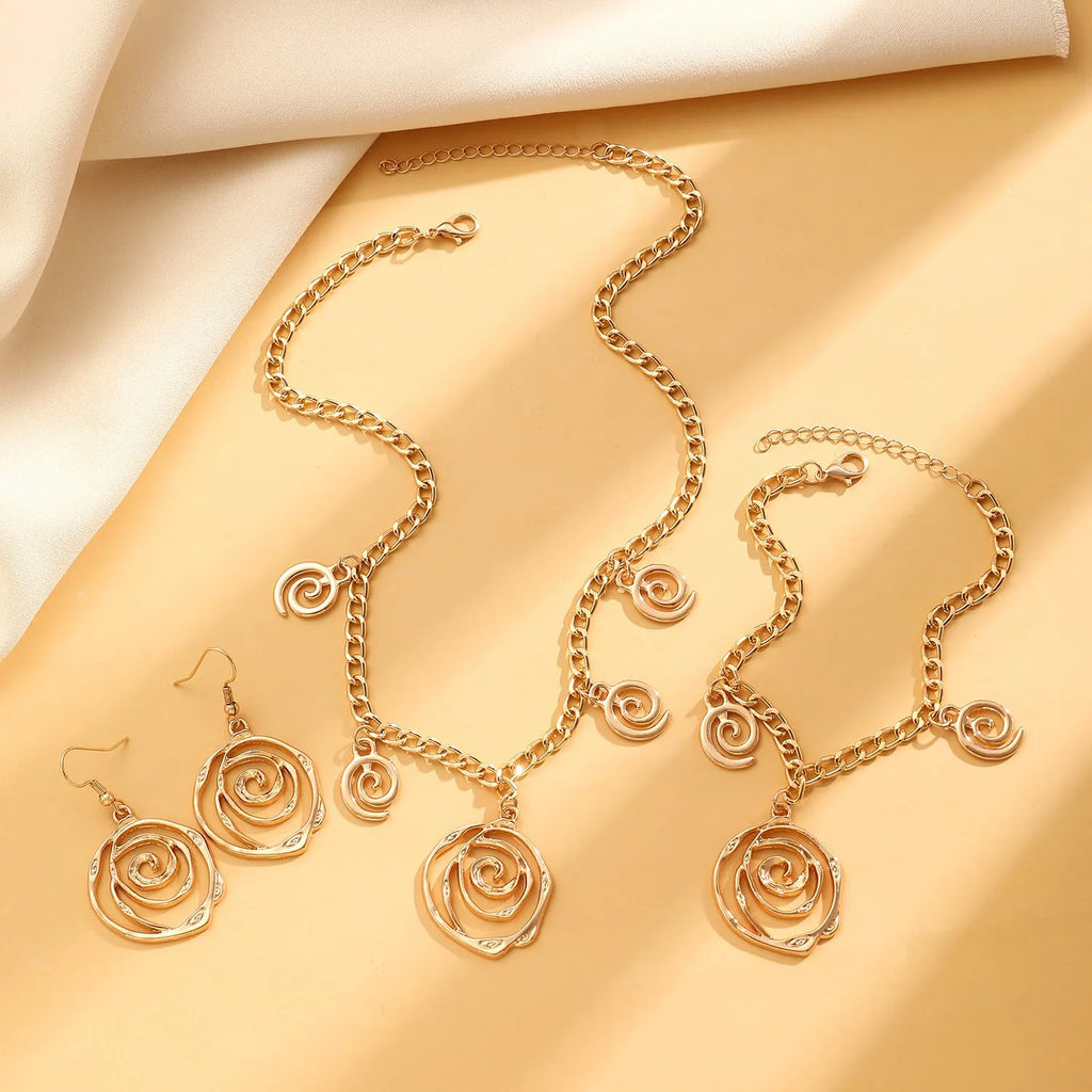 Geometric spiral donut jewellery set showing necklace, bracelet, and earrings in gold electroplated finish