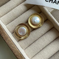 A pair of round, gold-tone retro style metal earrings for women