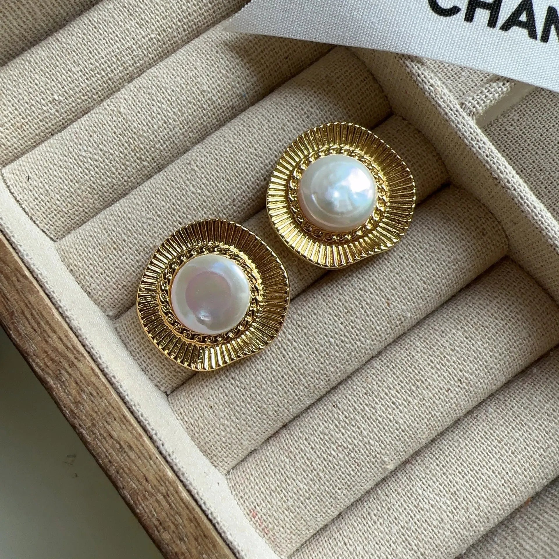 A pair of round, gold-tone retro style metal earrings for women