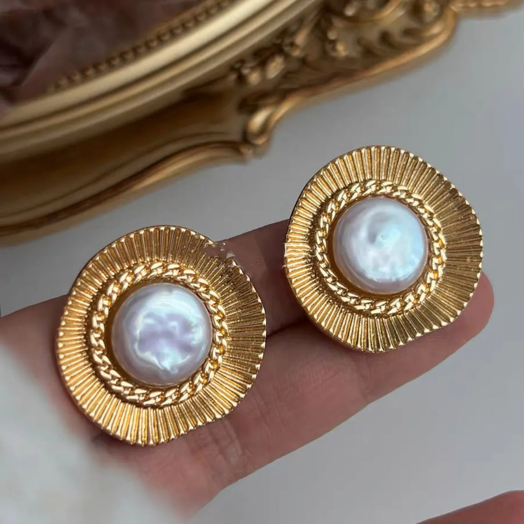 A pair of round, gold-tone retro style metal earrings for women