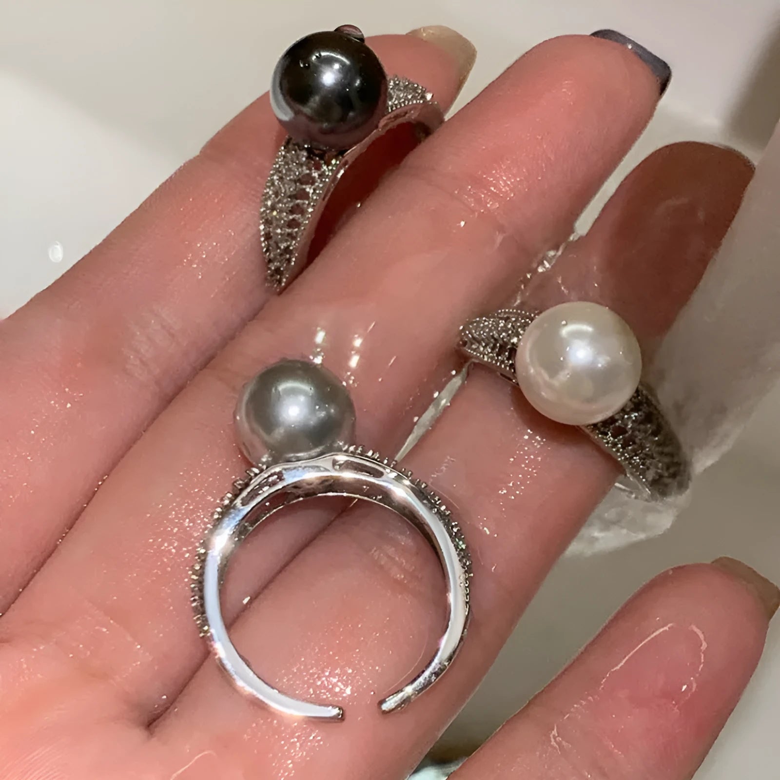 Adjustable geometric copper ring for women with a black pearl on an open band.