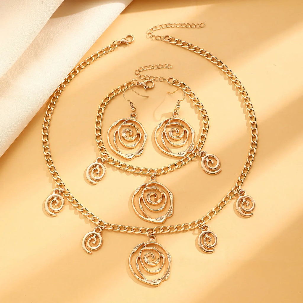 Geometric spiral donut jewellery set showing necklace, bracelet, and earrings in gold electroplated finish
