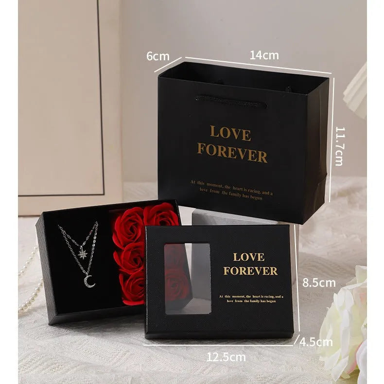 Six red soap flowers arranged in a black gift box with a matching handbag, a Valentine's Day gift set.