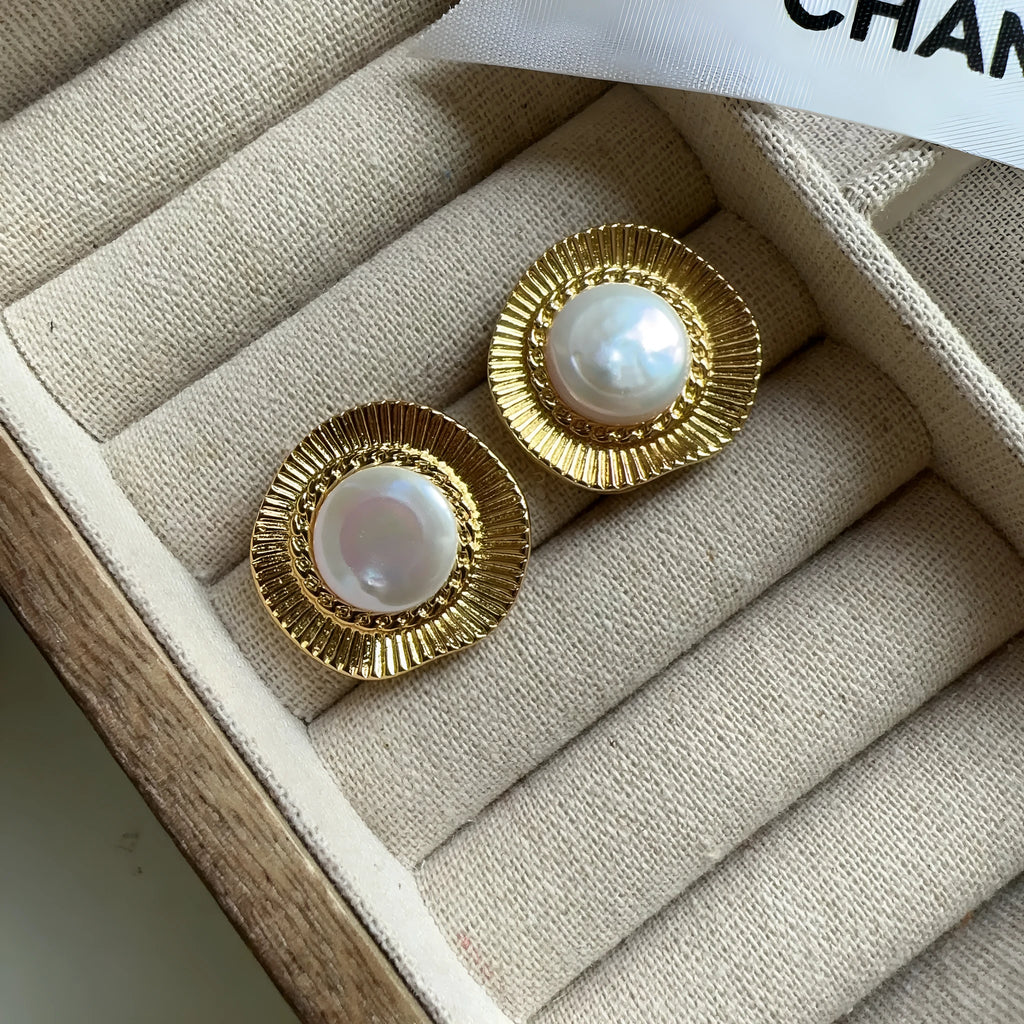 A pair of round, gold-tone retro style metal earrings for women