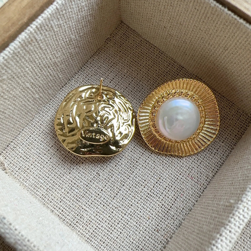 A pair of round, gold-tone retro style metal earrings for women