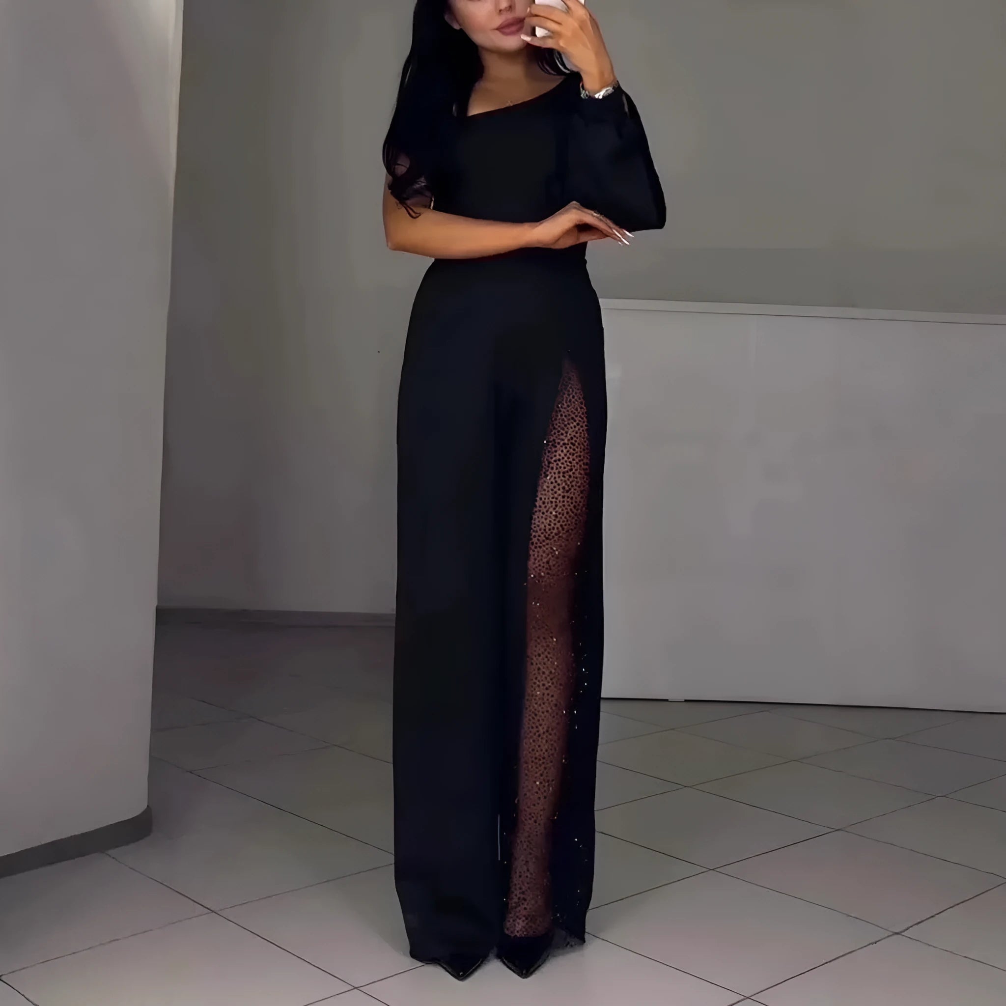 Women's black polyester jumpsuit with an oblique shoulder and a high slit on the leg.