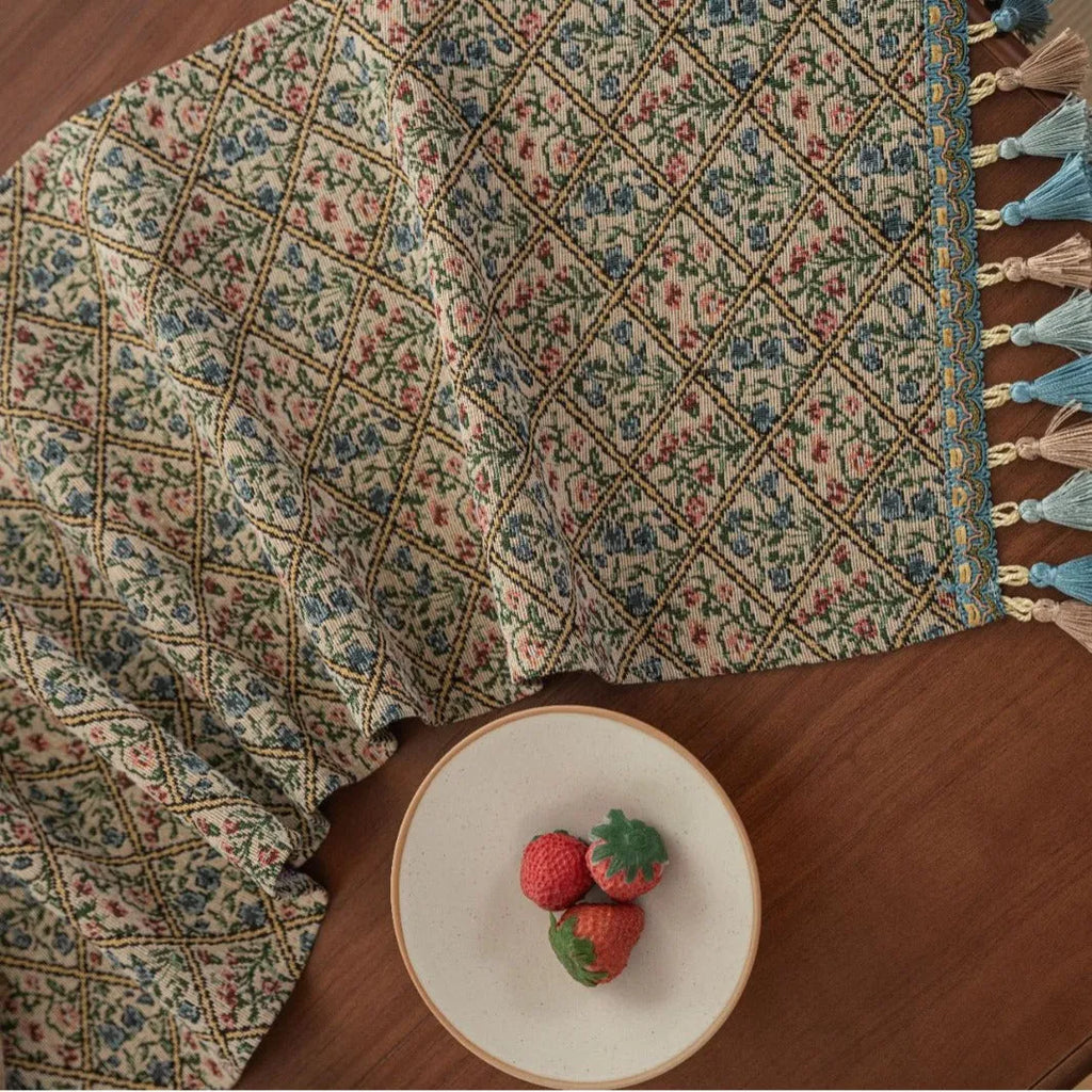 Dark blue striped jacquard table runner with tassel trim laid on a wooden table.