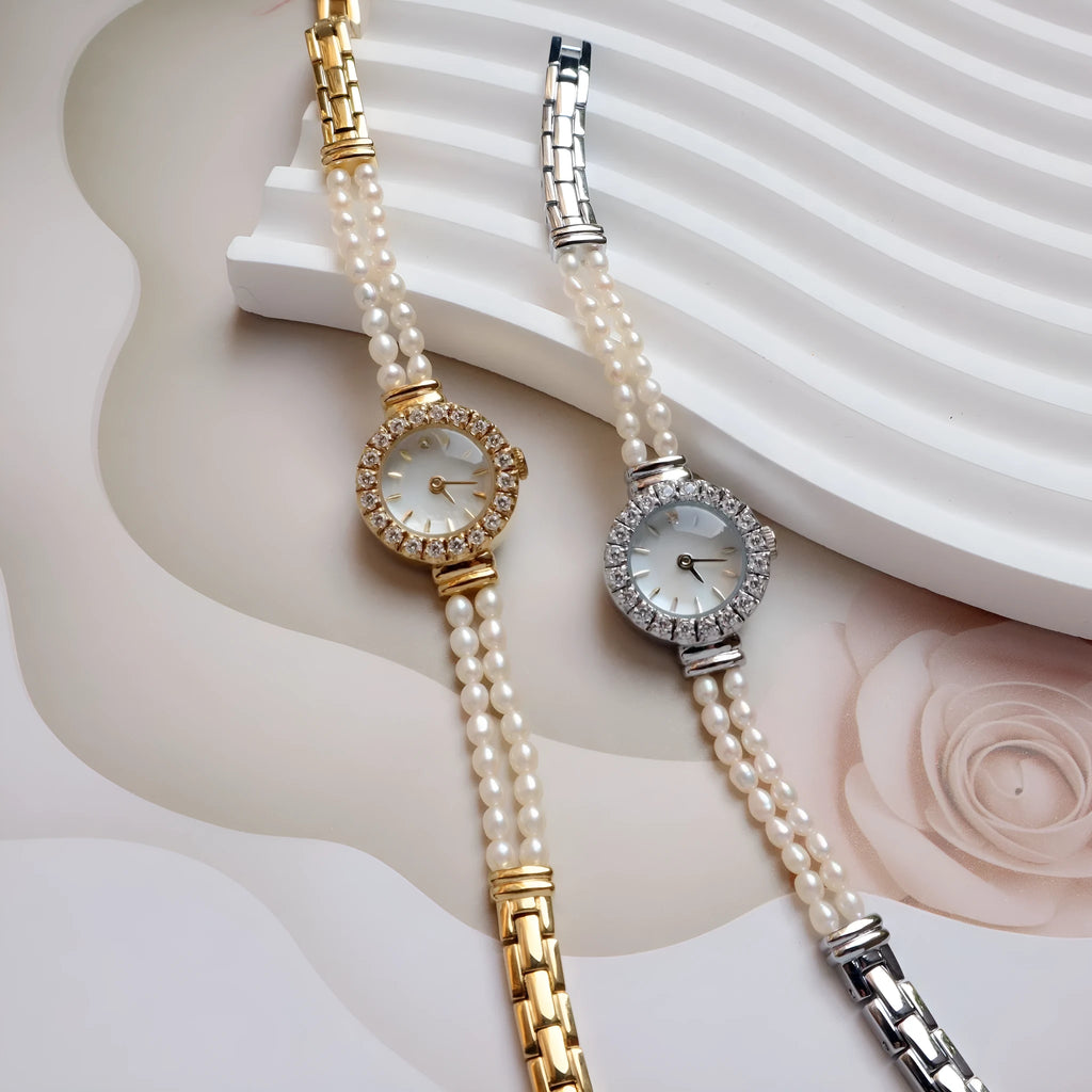 Light gold women's bracelet watch with freshwater pearls, round 18mm dial, and stainless steel strap.