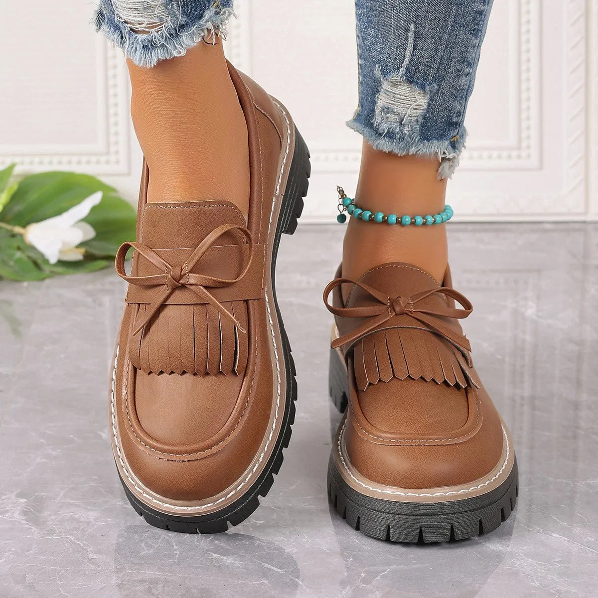 Black faux leather women's loafers with a tassel decoration and a thick chunky heel