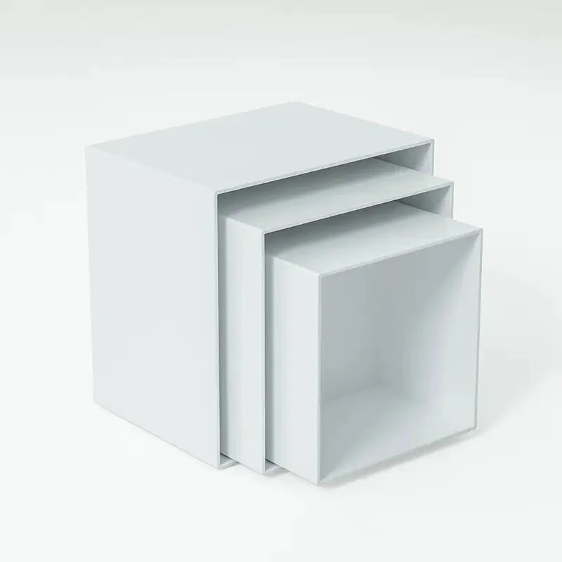 Set of six white plastic cube dessert display stands arranged on a tabletop.