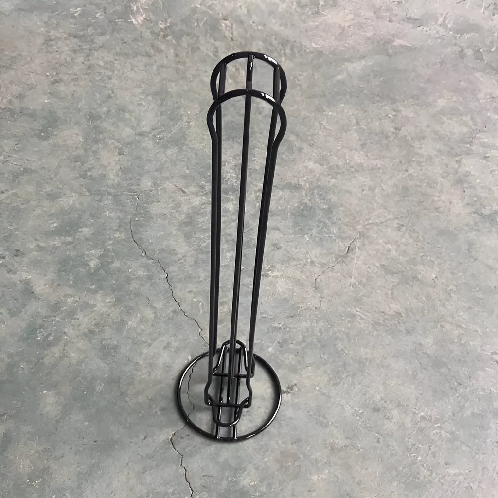 Black wrought iron coffee capsule storage rack holding pods on shelving, modern simple design.