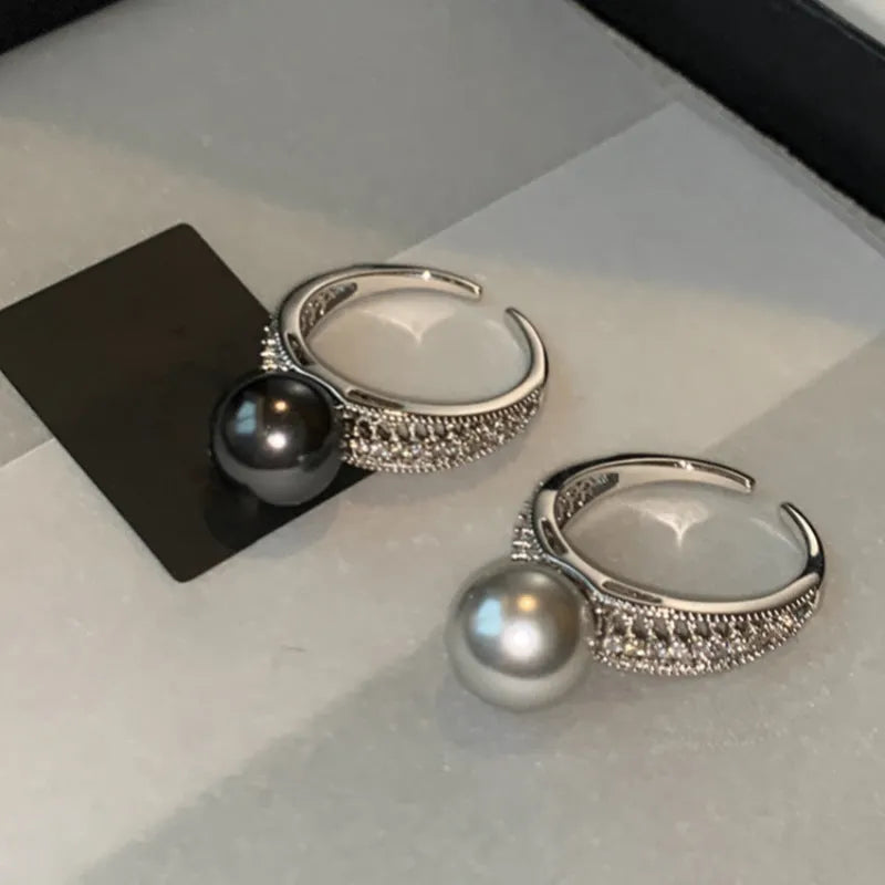Adjustable geometric copper ring for women with a black pearl on an open band.