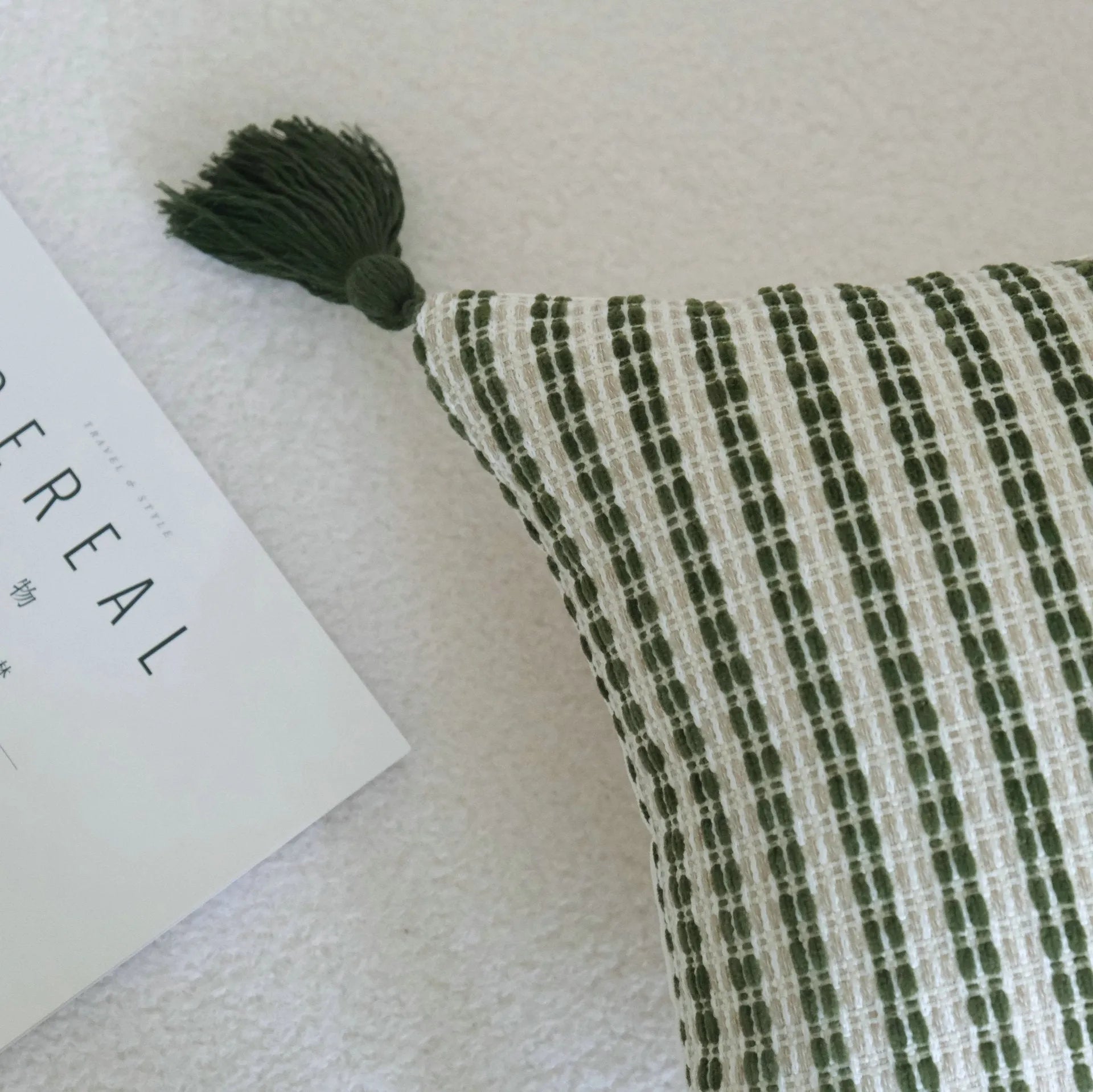 Green decorative pillow with tassel or beaded design on a cotton linen blend cover.