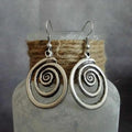 Silver geometric spiral distressed retro style earrings with a folk art design