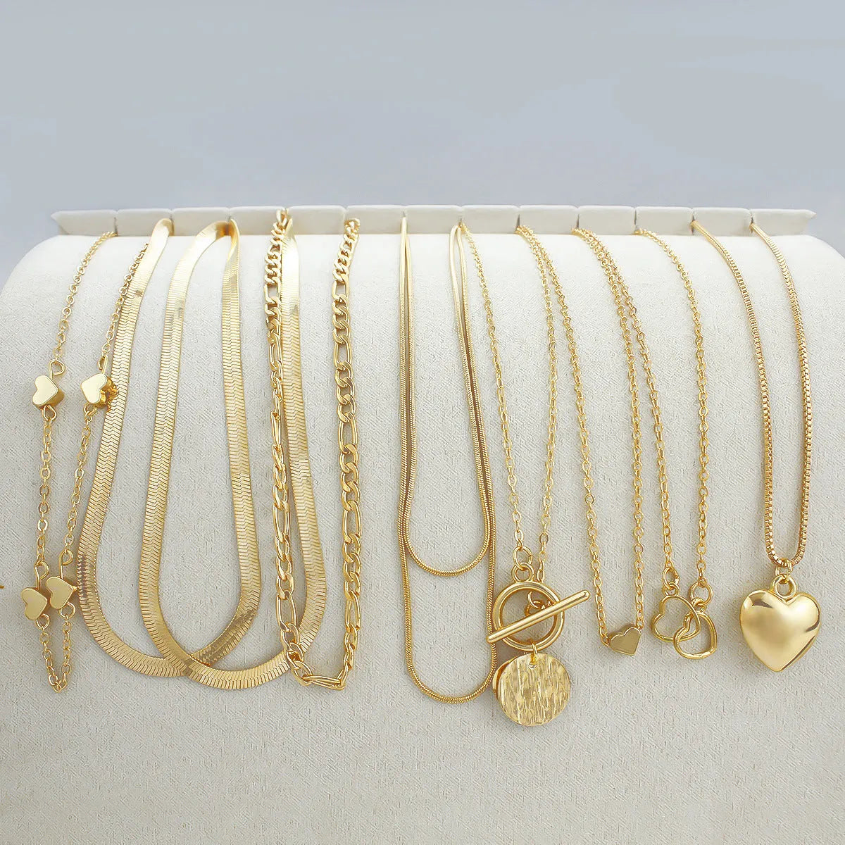 Ten gold electroplated necklaces with alloy pendants on adjustable snake bone chains