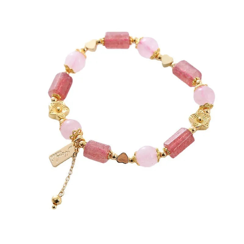 Pink strawberry crystal bracelet with star-shaped beads and a small heart charm on a white background