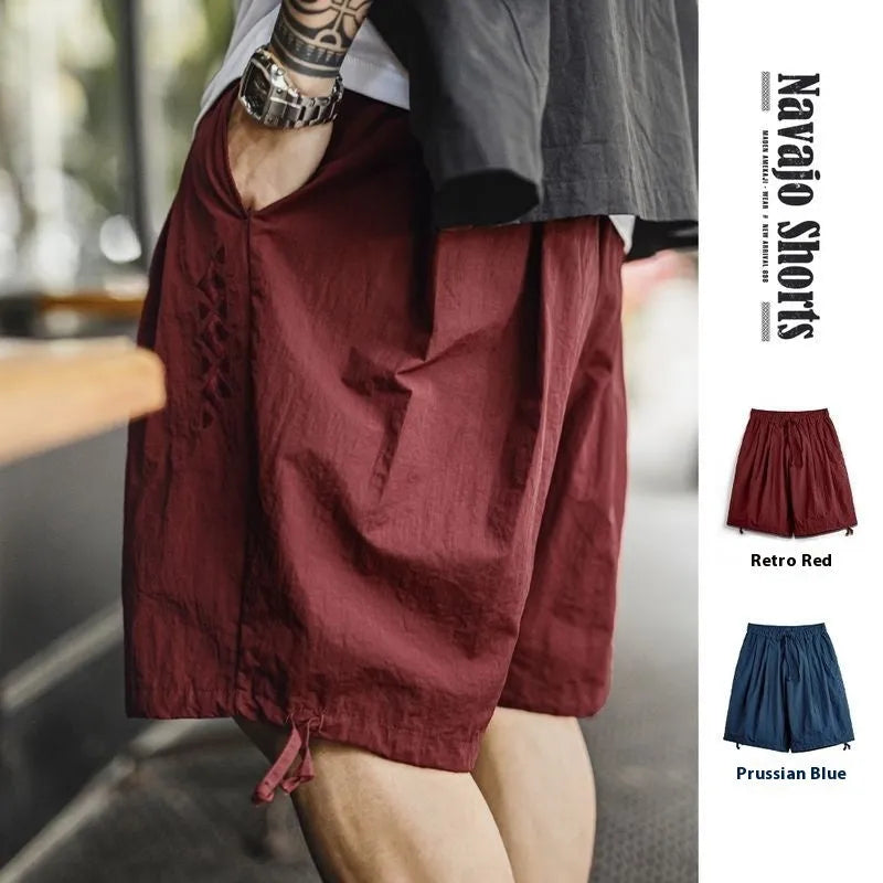 Men's loose fit nylon shorts in Prussian Blue with embroidered detailing