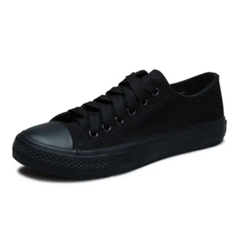 Women's solid colour canvas slip-on sneaker in black on a white background.