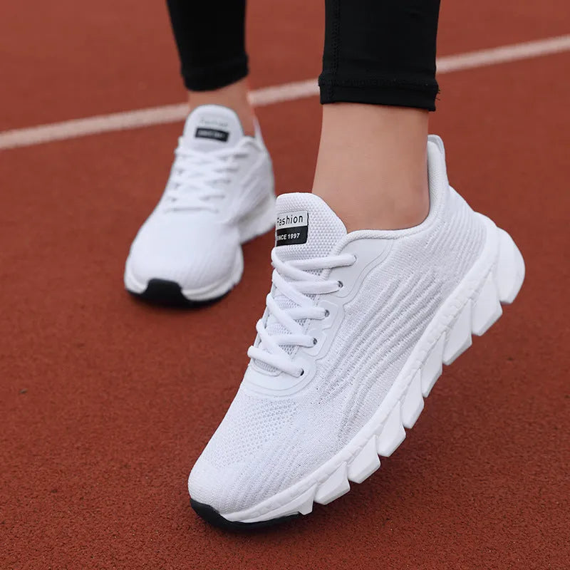 Women's low-top black and white running sneakers with cross-strap detail and MD sole.