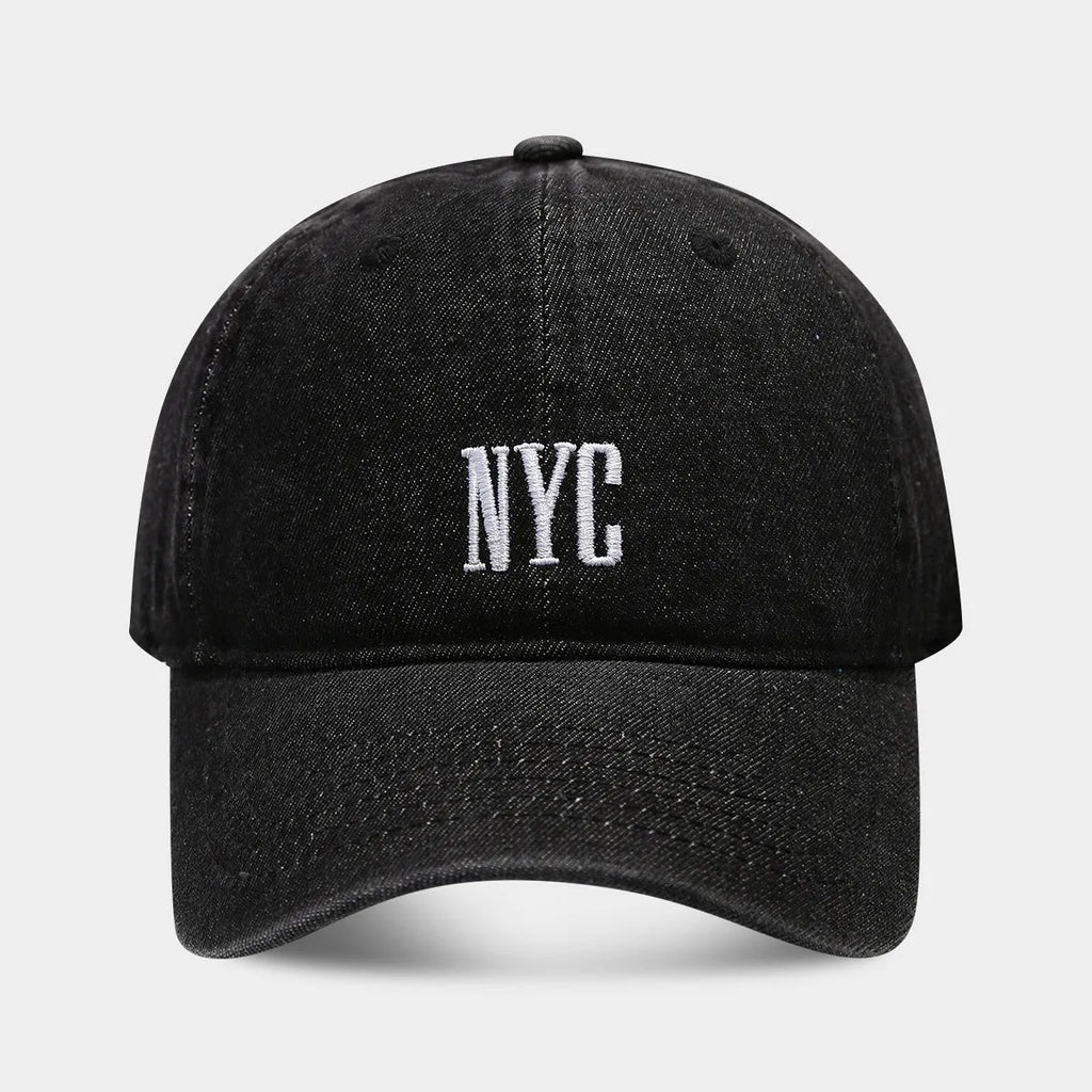 Retro style denim peaked cap with a large alphabet letter on the front, shown in light blue.