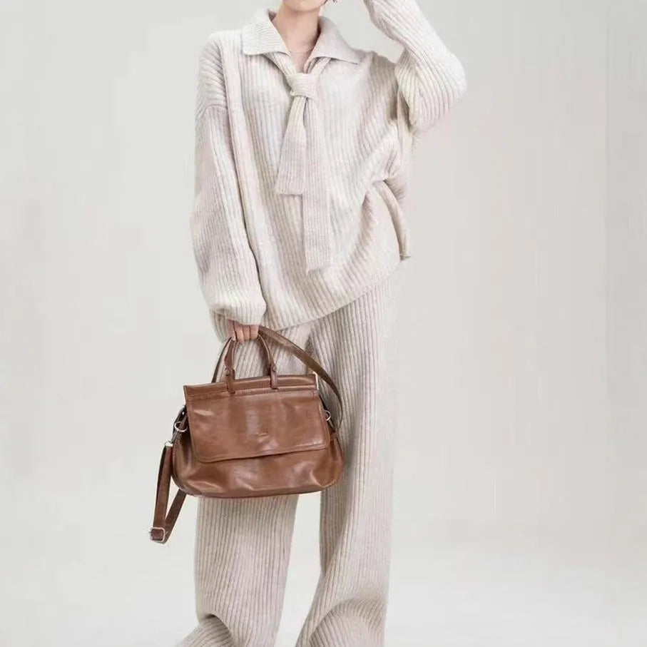 Woman wearing a beige acrylic knit sweater top and matching trousers from a casual two-piece set.