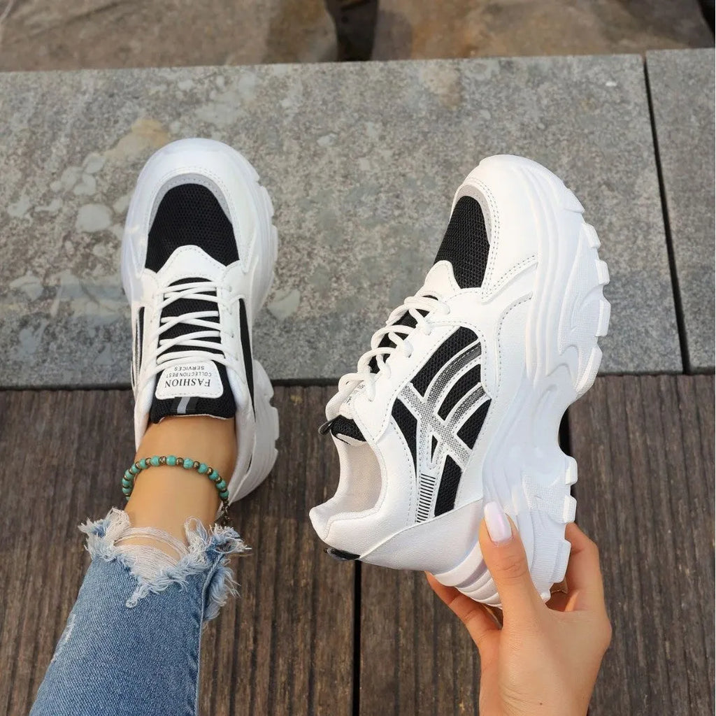 Women's platform wedge sneakers in black or white with mesh lining, rubber sole, front lace-up, round toe, and sewing thread detail.