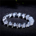 Women's white crystal pyramid bead bracelet with Ruyi design motif on a wrist.