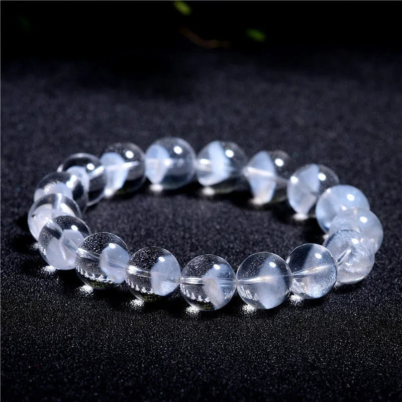 Women's white crystal pyramid bead bracelet with Ruyi design motif on a wrist.