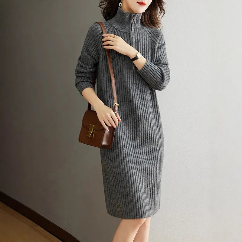 Beige half-zip woolen skirt with stand collar and long sleeves in a loose, straight dress cut.