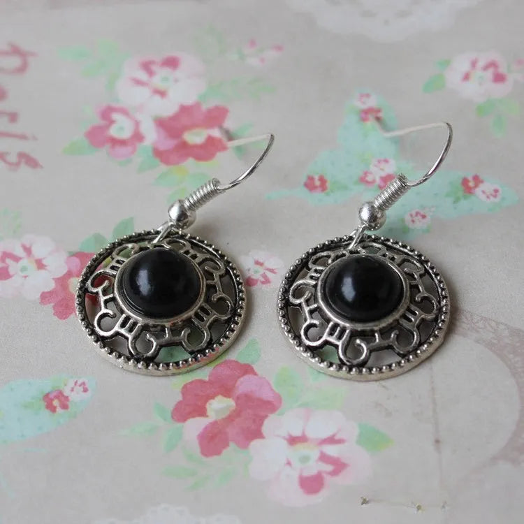 Handmade Miao-inspired silver and turquoise geometric flower disk earrings in black, blue, and red.